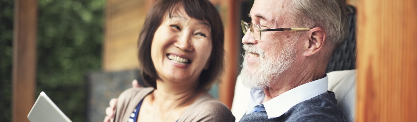 Couple sitting on porch with tablet