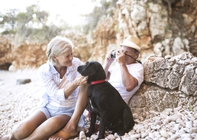 Senior Couple with Black Dog on Beach