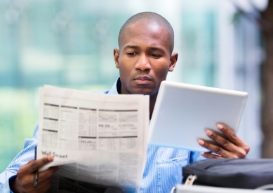Black man looking at newspaper